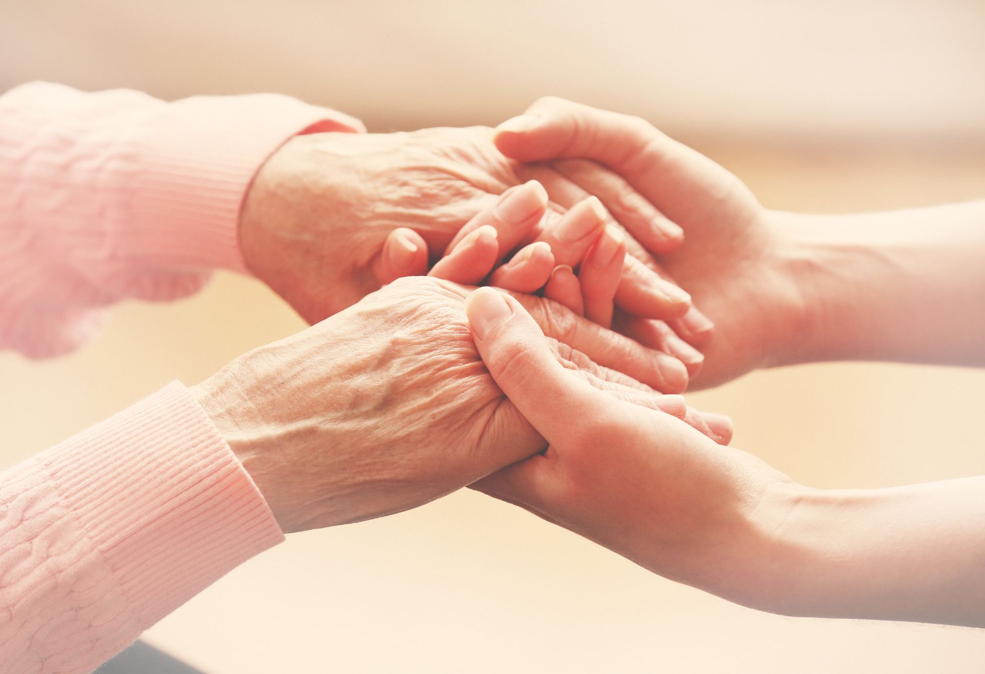 Image showing elderly person's hands held by a young person's hands.